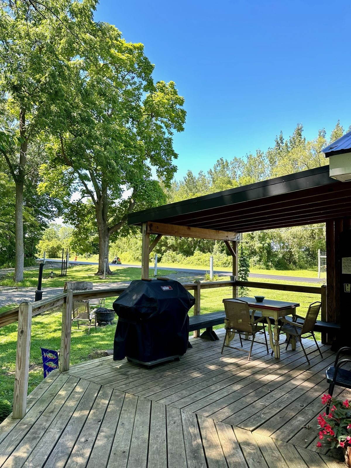 Outdoor dining and gas grill on the deck, waterside fire pit in evening light
